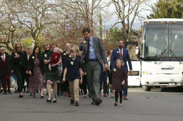 A group of people walk off a bus