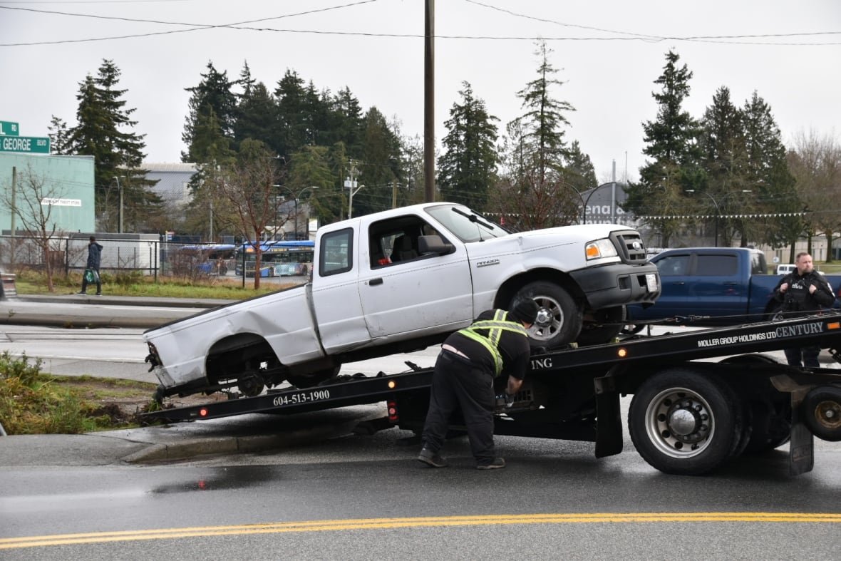 A white pickup truck is seen being towed away.