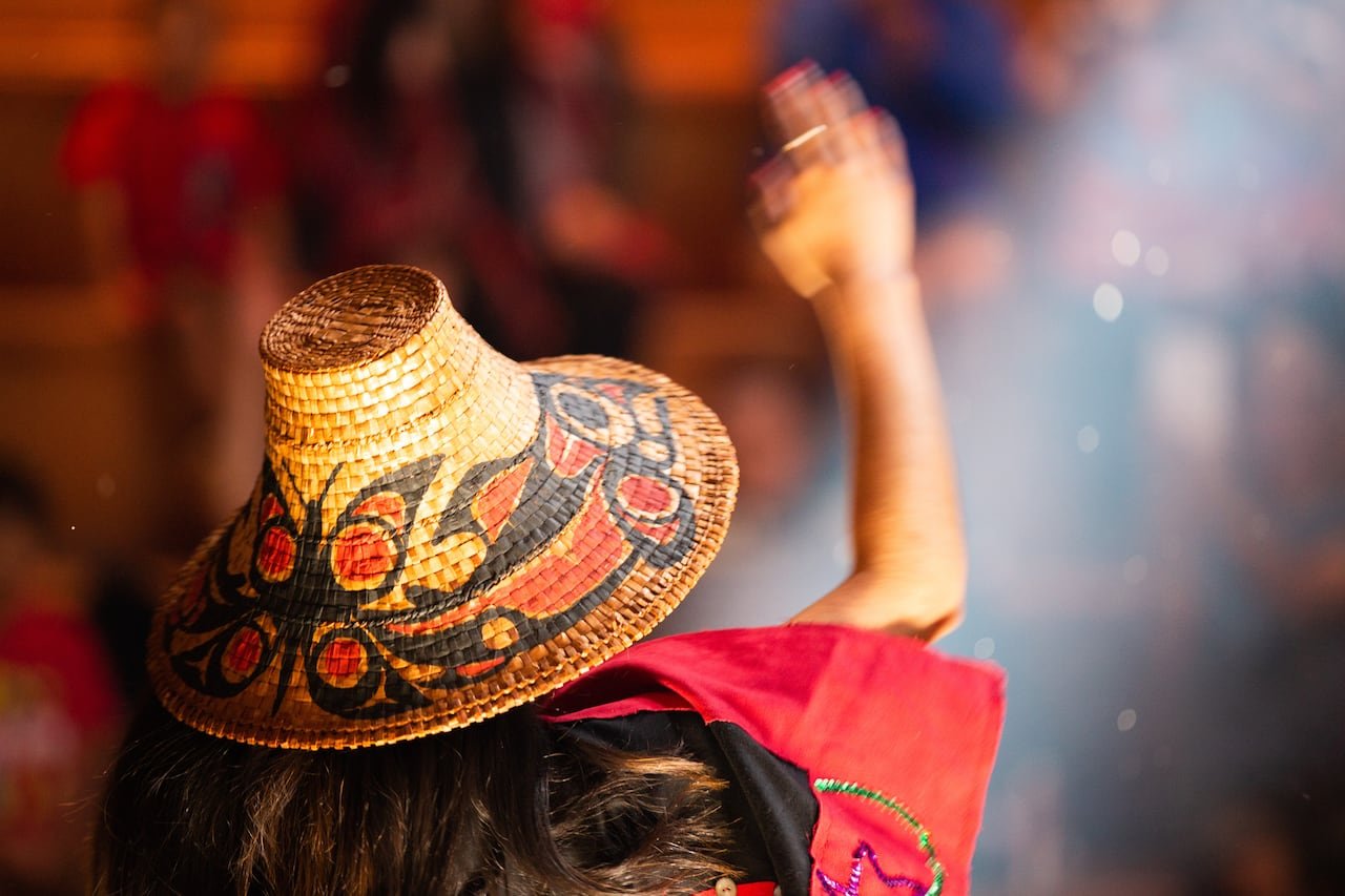 Image of a woman in traditional attire raising her arm.